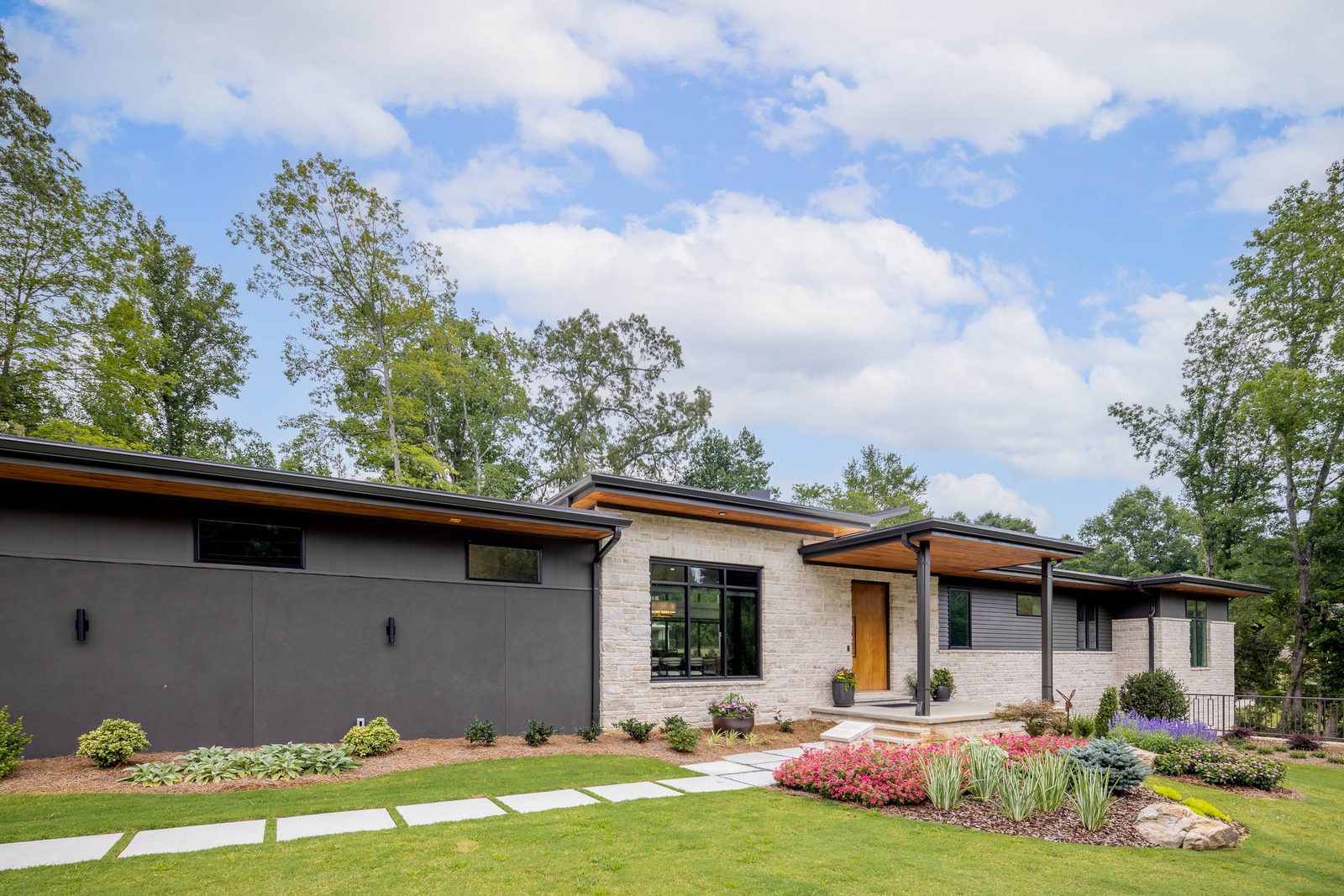 Front and side elevation with low-slope roof over the lawn — The Ortiz Home, custom home built by Ironwood Construction Group in Sugar Hill, Georgia