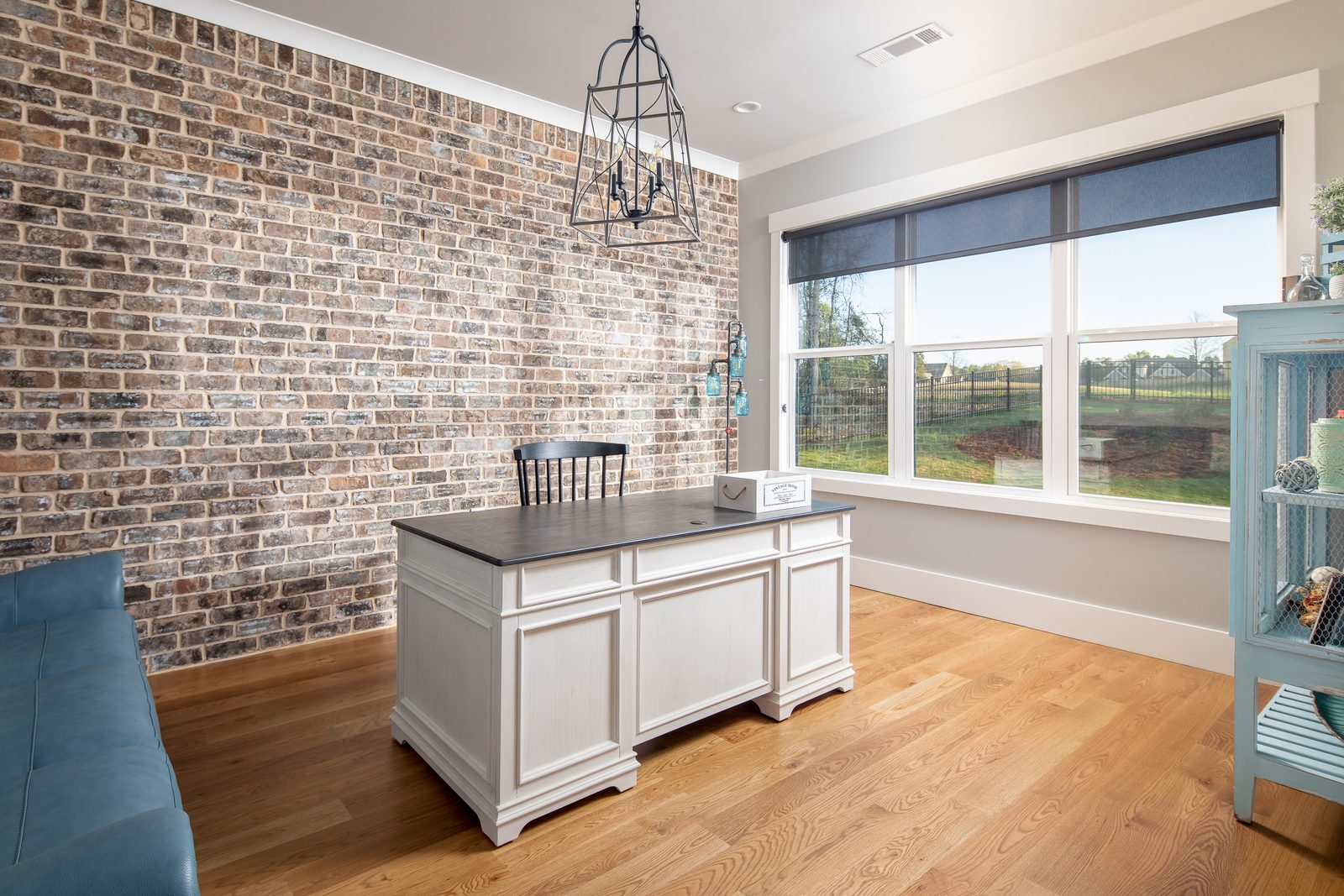 Kitchen with exposed brick wall and white island — Spring 2020 Custom Home, custom home built by Ironwood Construction Group