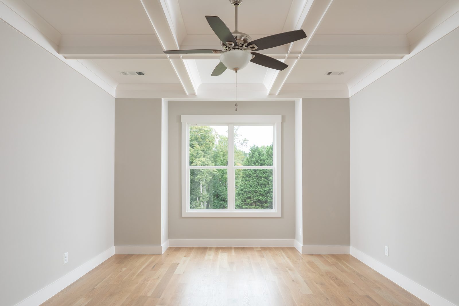 Primary bedroom with coffered ceiling and ceiling fan — Shadburn Ferry, custom home built by Ironwood Construction Group in Buford, Georgia